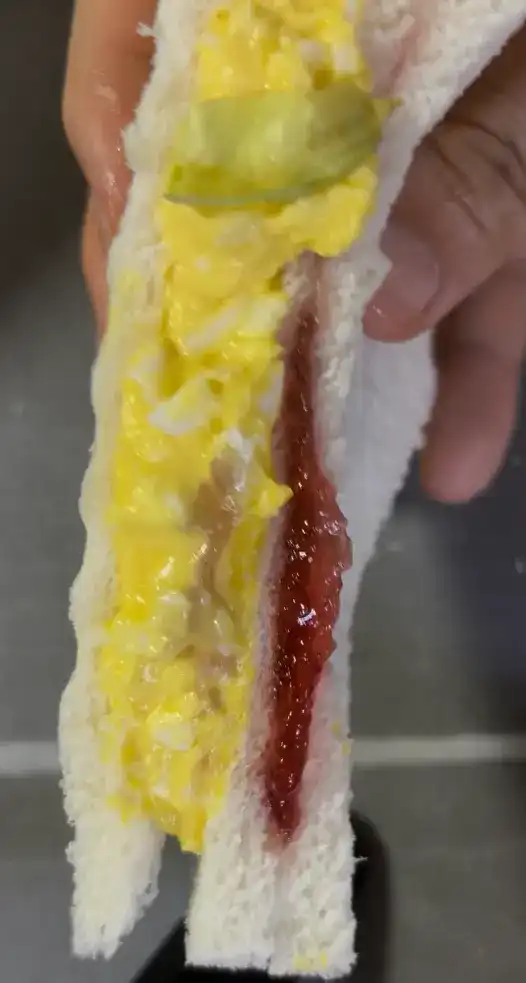 Close-up of the ham, cheese, and strawberry jam half with crisp lettuce