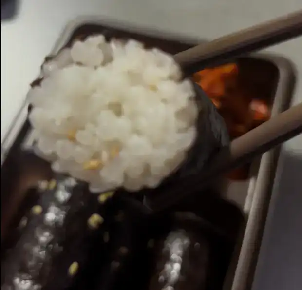 A close-up of a single mini seaweed rice roll