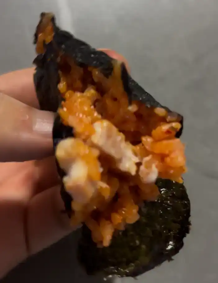 A half-eaten piece of the GS25 Spam Kimchi Fried Rice Triangle Kimbap