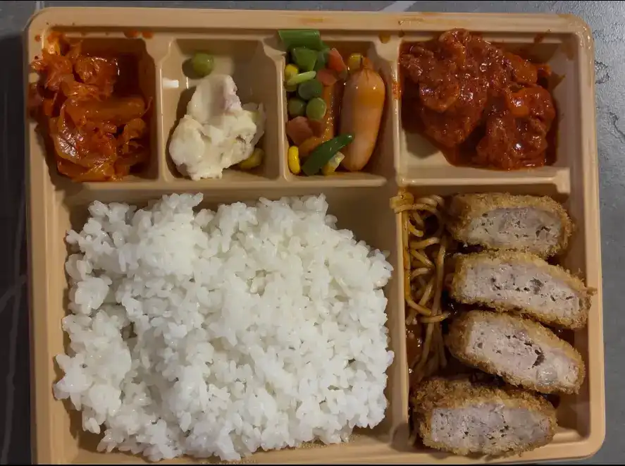 The unwrapped bento box showing the rice and all side dishes