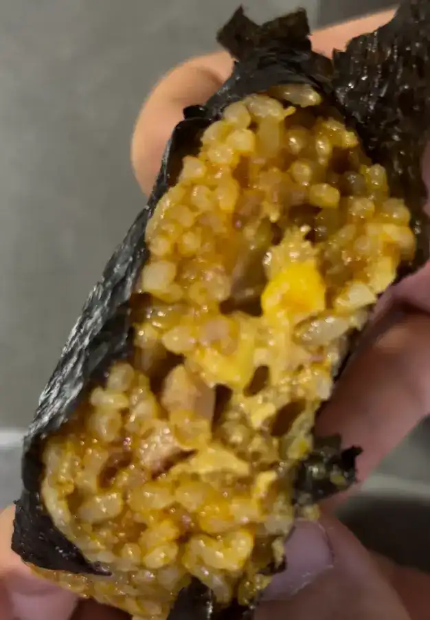 The inside filling of the Curry Ham Mayo Samgak Gimbap showing ham chunks