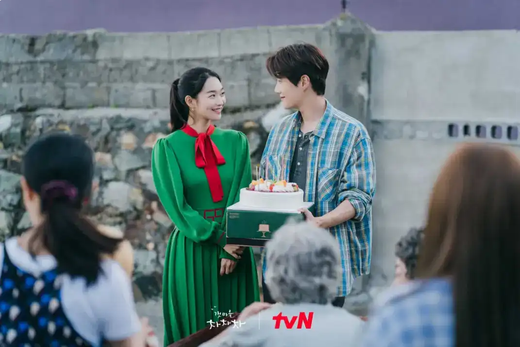 A heartwarming scene of Gongjin residents gathering together, representing the community spirit and healing message of the drama