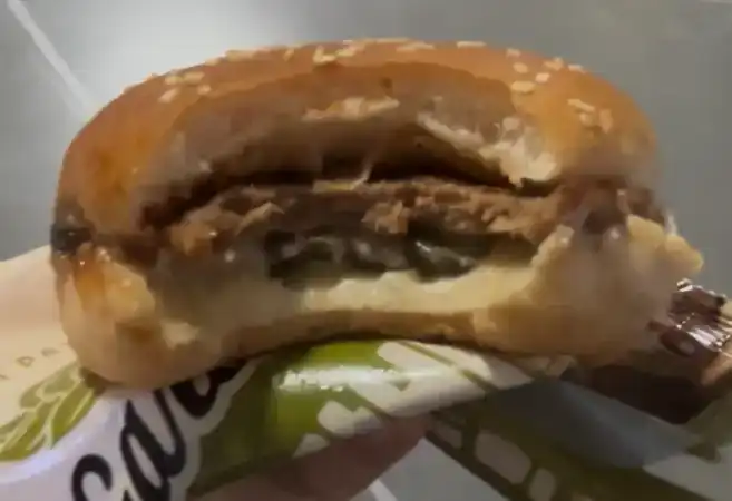 Inside look of the GS25 Garlic Galbi Burger showing the patty and sweet galbi sauce