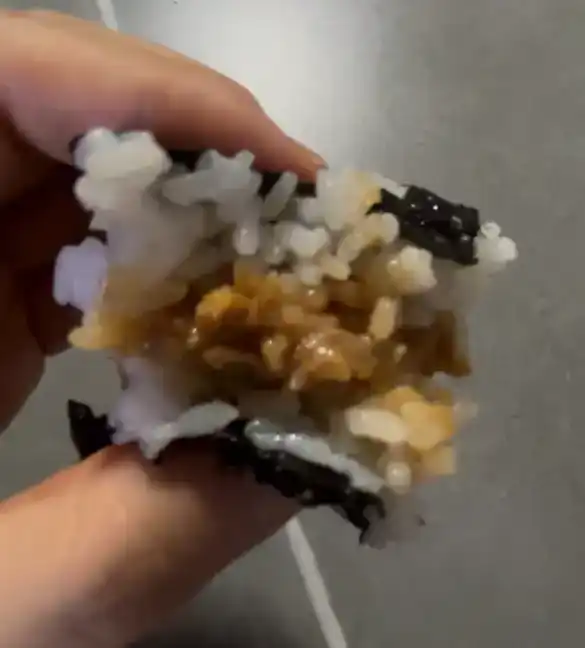 A half-eaten piece of the GS25 Soft Chicken Mayo Triangle Kimbap