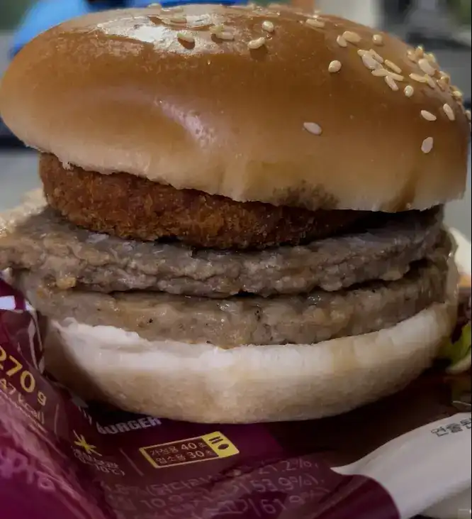 The unwrapped triple burger showing the three stacked patties