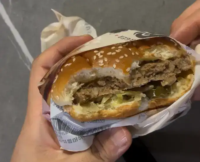 Showing the thick patty and mushrooms while eating the burger