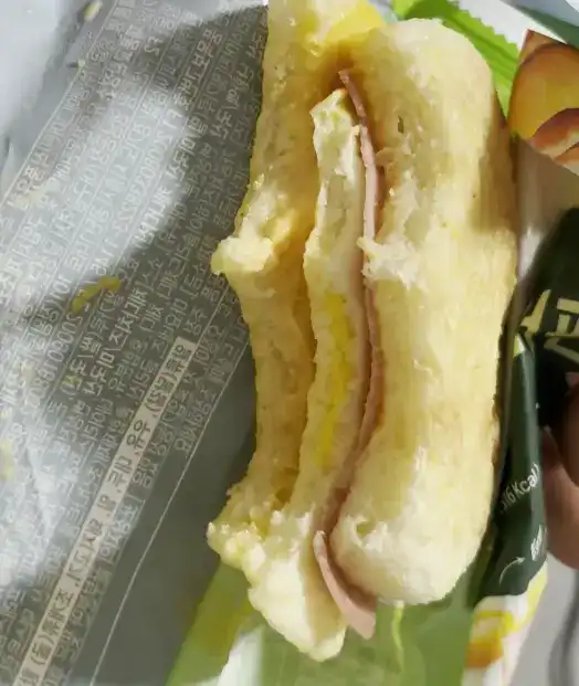 A close-up of a bite taken from the Ham & Egg Muffin revealing the layers