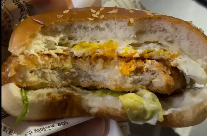 Inside the CU Chicken Egg Spicy Burger showing the chicken patty and egg