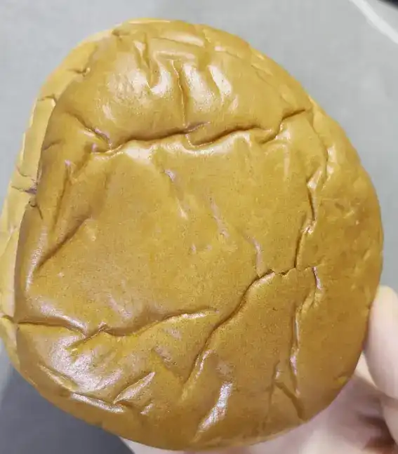 The unwrapped red bean cream bread showing its classic golden-brown crust