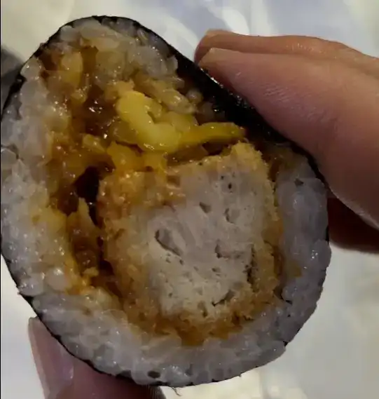 A close-up of a single slice showing the thick pork cutlet in the center