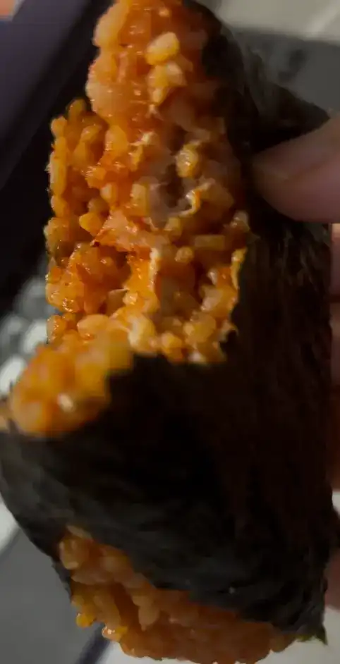 Close-up of the spicy tuna filling inside the red-seasoned rice