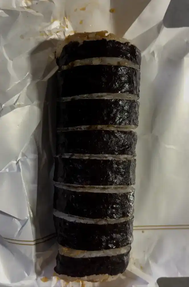 The unwrapped pork cutlet kimbap showing the full roll before slicing