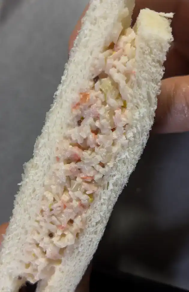 The unwrapped crab salad sandwich showing its thick, crustless bread