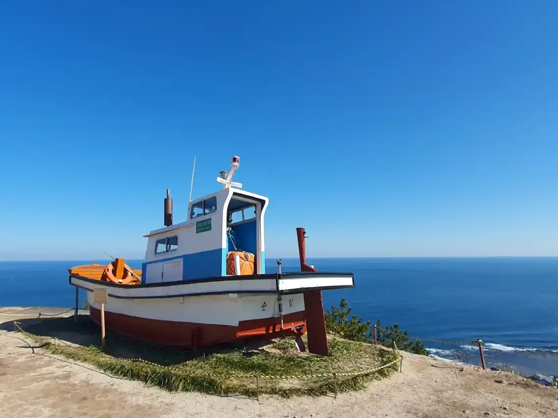 Panoramic view of the serene seaside village Gongjin in Pohang, featuring the iconic red lighthouse from the K-drama Hometown Cha-Cha-Cha