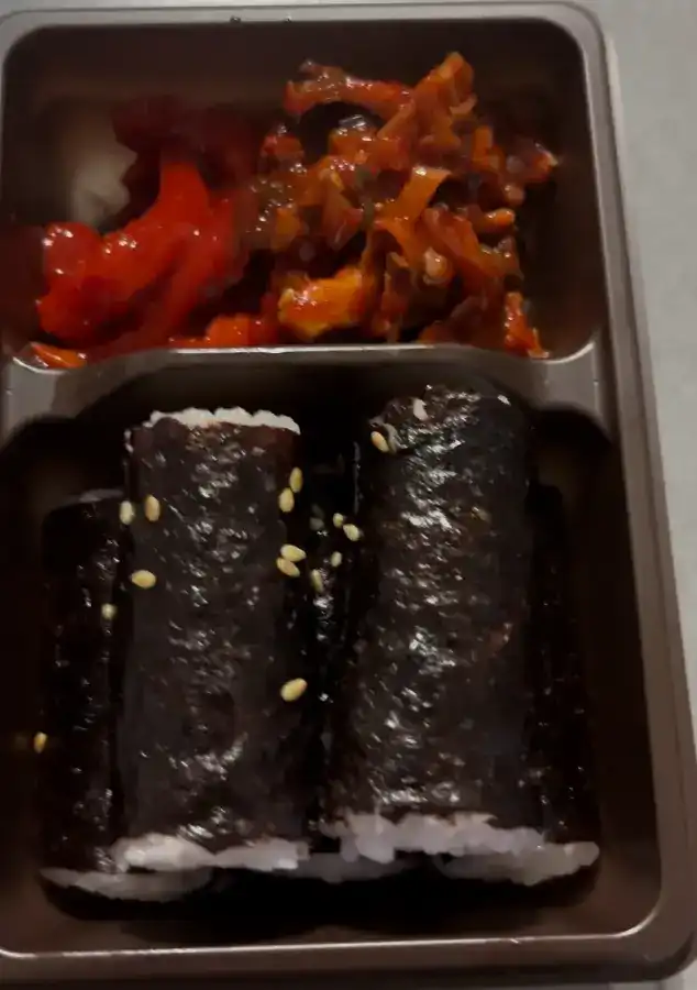 The unwrapped Chungmu Kimbap set showing mini rolls and side dishes
