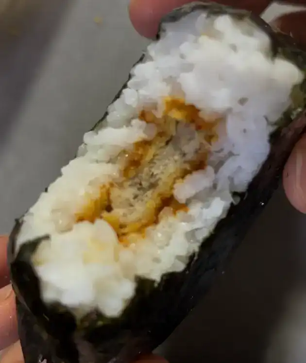 A close-up of the interior showing the thin pork cutlet patty and rice ratio